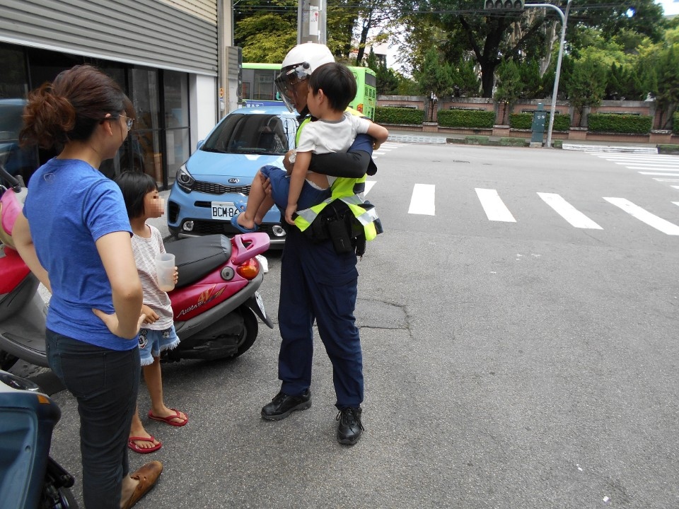 2歲小孩跑到馬路赤腳丫奔跑 霧警送回家人懷抱。(特派員孫崇文翻攝)