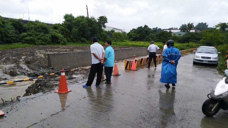 大寮區24小時累計雨量破百，區長胡俊雄勘查拷潭大排排水情形。(記者張文晃翻攝)