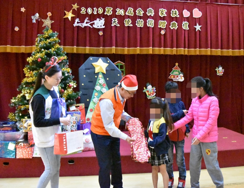 南台中家扶扶幼委員會謝勝騏主委(左二)把聖誕禮物交到孩子們手上。(南台中家扶提供)。(記者張越安翻攝)