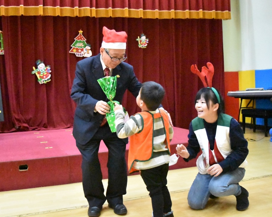 家扶基金會劉國璋副執行長(左)親手將聖誕禮物送給孩子。(南台中家扶提供)。(記者張越安翻攝)