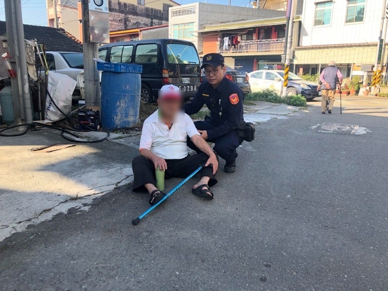 老翁手腳無力路倒 員警協助送醫救護。(記者蘇杉郎翻攝)