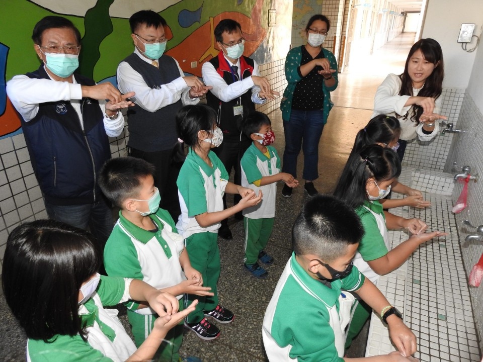 開學日 林明溱幫學童量額溫 教學正確洗手步驟。(記者陳金泉翻攝)