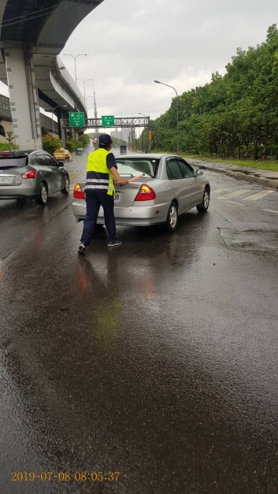 停等紅燈車拋錨 鳳警冒雨解圍。(記者劉明吉翻攝)