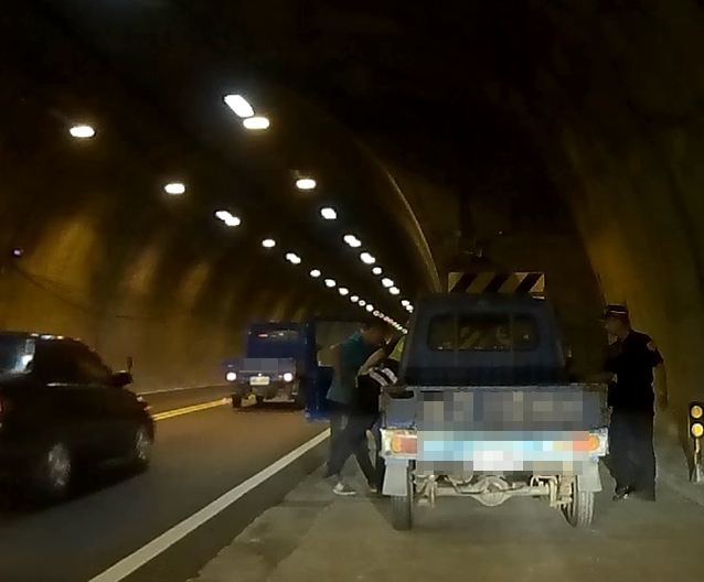 隧道內車沒油誤以為故障 路過暖警伸援手。(記者劉明吉翻攝)