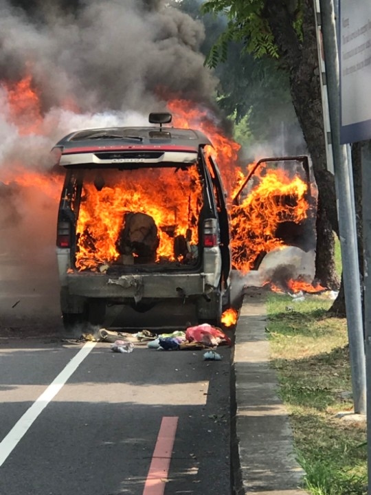 汽車疑後車廂打火機自燃起火 霧勇警提滅火器協助滅火。(特派員孫崇文翻攝)