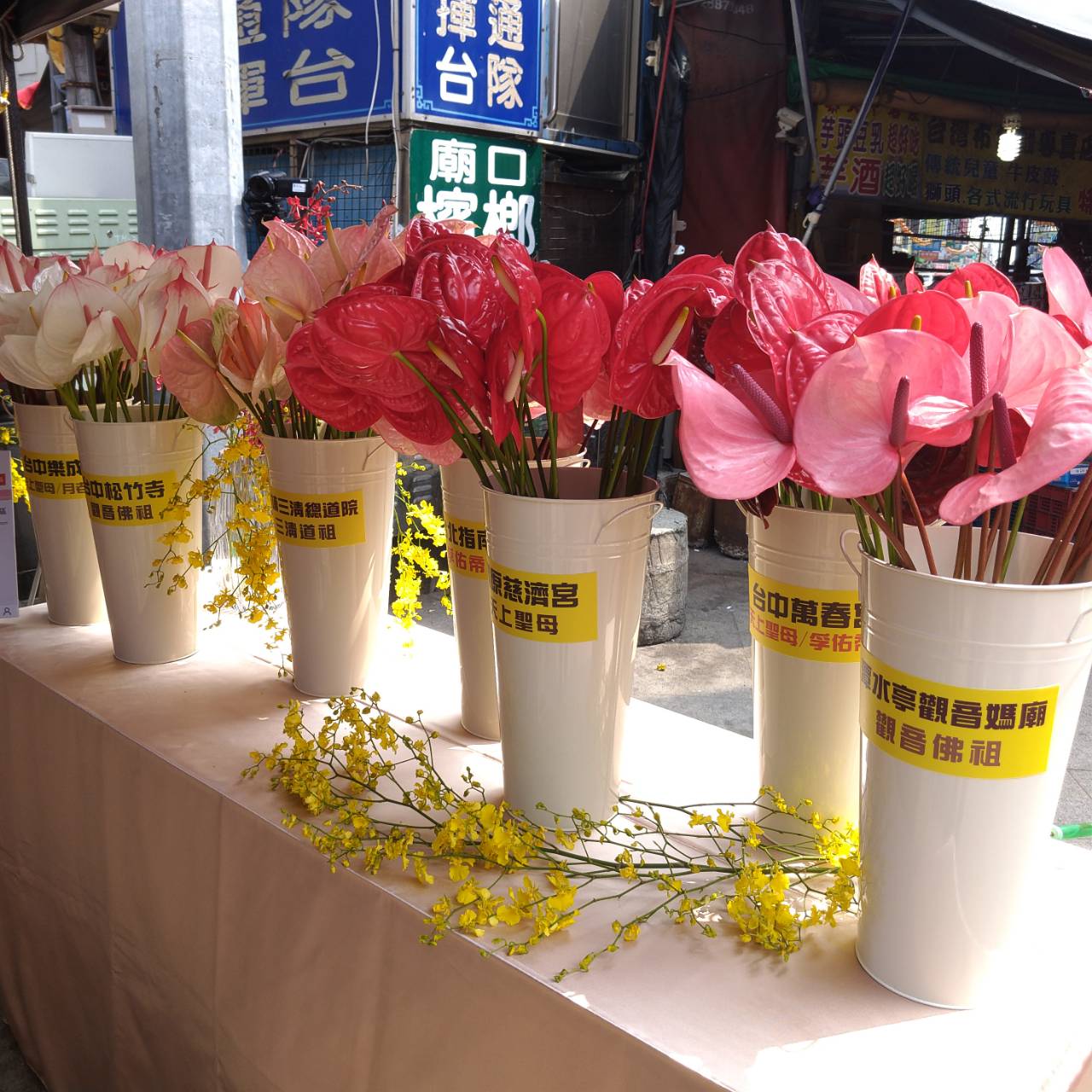 廟方提供單支鮮花讓民眾持花或供花祈福。(記者張越安翻攝)