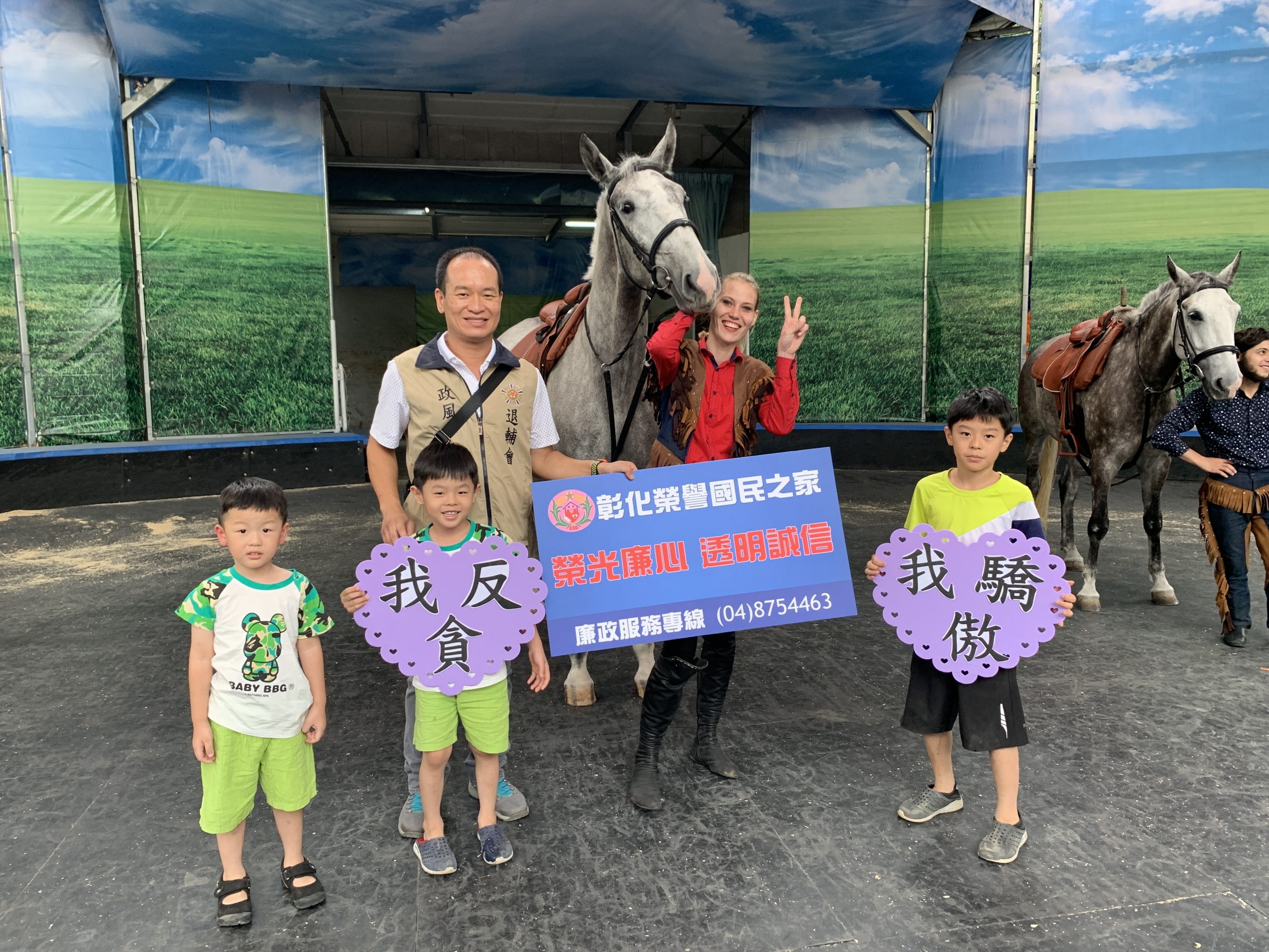 政風室主任劉昌元與學童手持宣導標語與來自斯洛伐尼亞的世界8大名馬「利比扎馬」合影