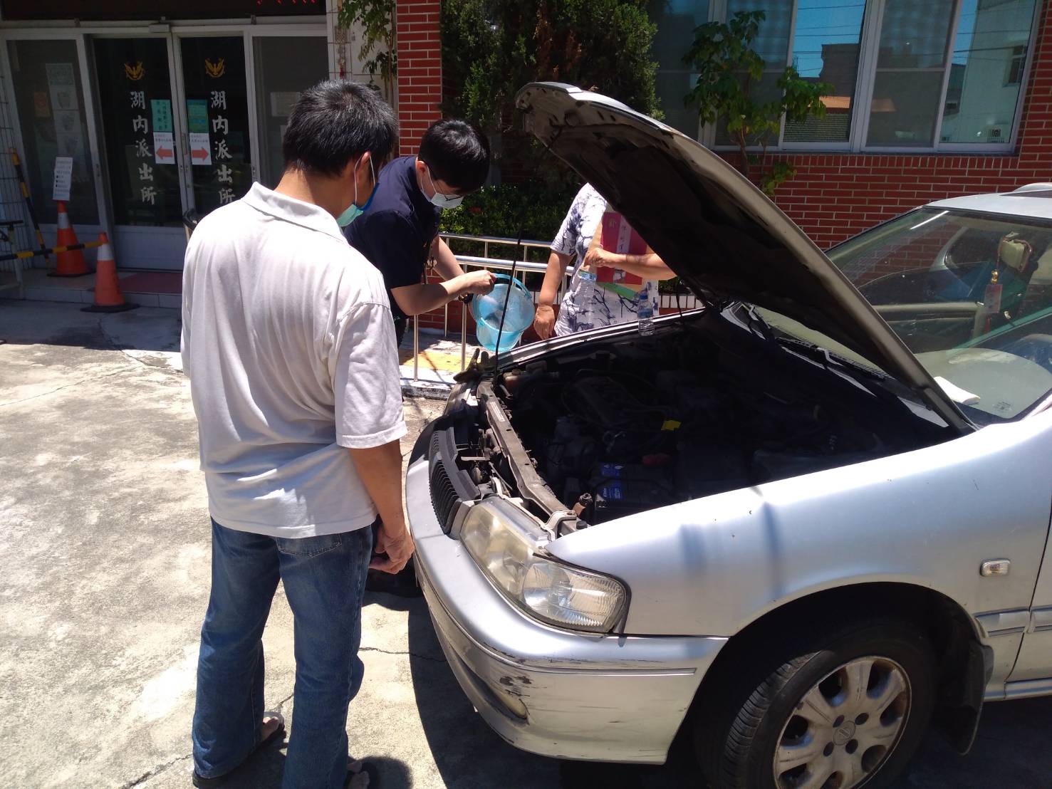 天氣太熱汽車罷工 幸有湖內警提水相助解危。(記者劉明吉翻攝)